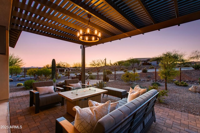 patio terrace at dusk with a pergola and an outdoor living space with a fire pit