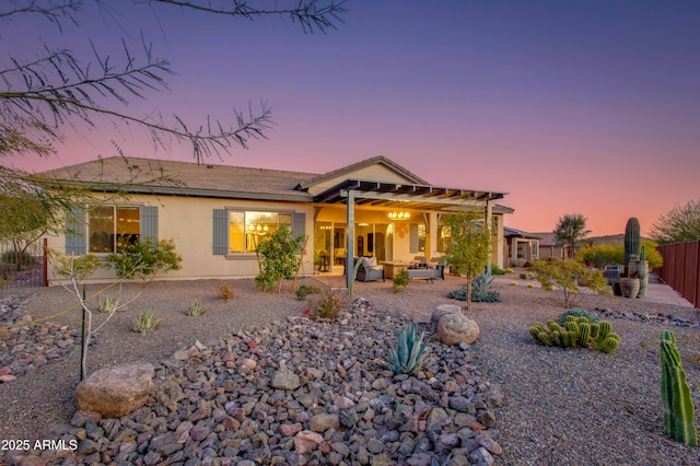 back house at dusk with outdoor lounge area and a patio