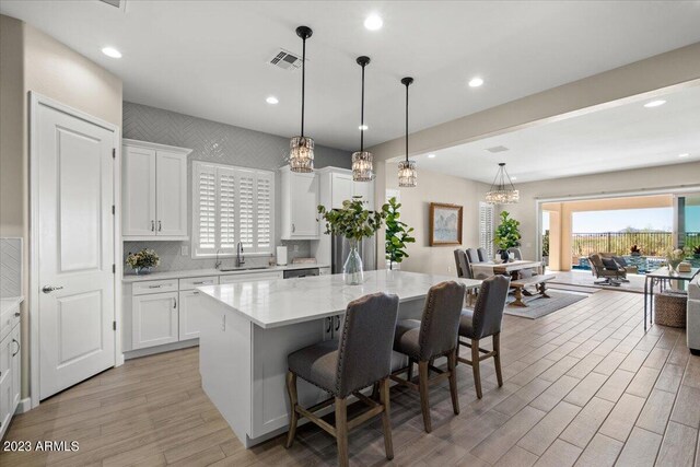 kitchen featuring white cabinetry, sink, a center island, and a breakfast bar area