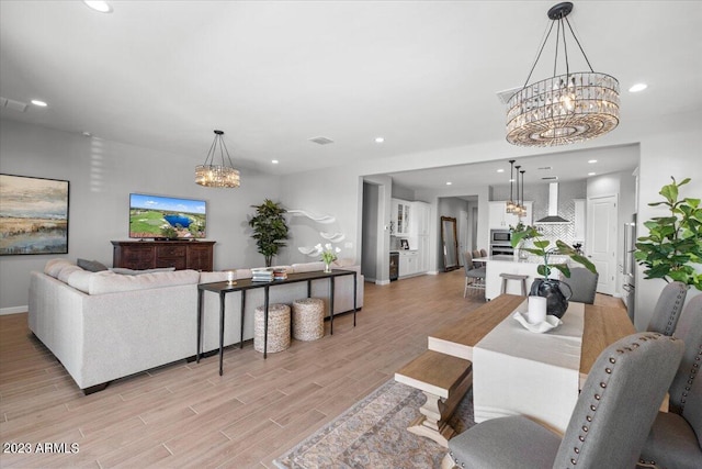 living room with a notable chandelier and light wood-type flooring