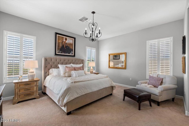 carpeted bedroom with an inviting chandelier