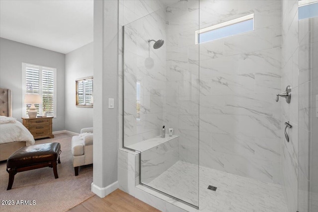 bathroom with wood-type flooring and a tile shower