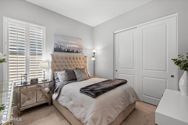 bedroom with light colored carpet and a closet