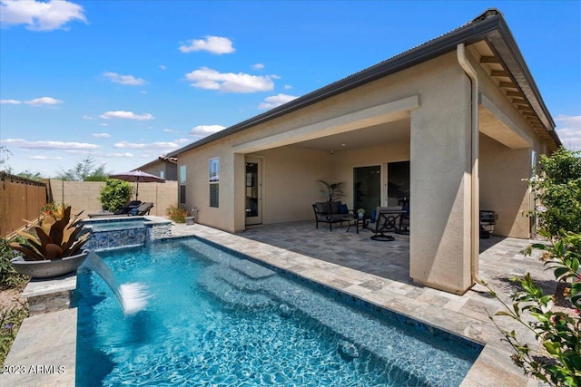 view of pool with a patio area, pool water feature, and an in ground hot tub