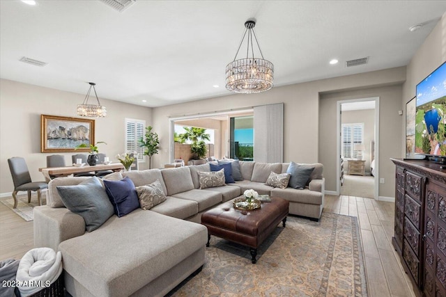 living room with an inviting chandelier and light hardwood / wood-style flooring