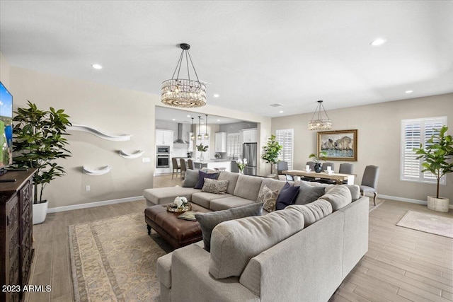 living room with a chandelier and light hardwood / wood-style floors