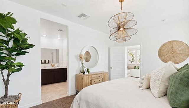 bedroom featuring ensuite bathroom, baseboards, visible vents, and light colored carpet