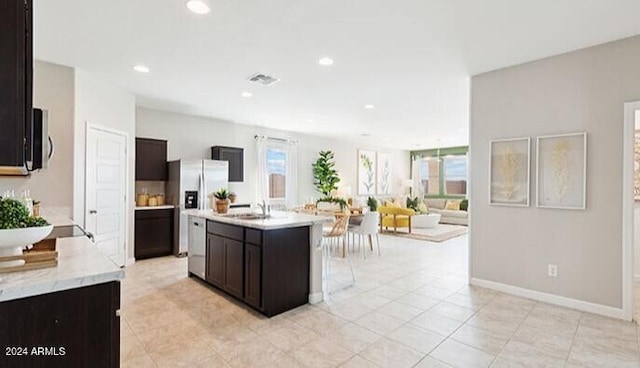 kitchen with visible vents, an island with sink, open floor plan, stainless steel appliances, and recessed lighting