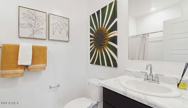 bathroom featuring curtained shower, vanity, and toilet