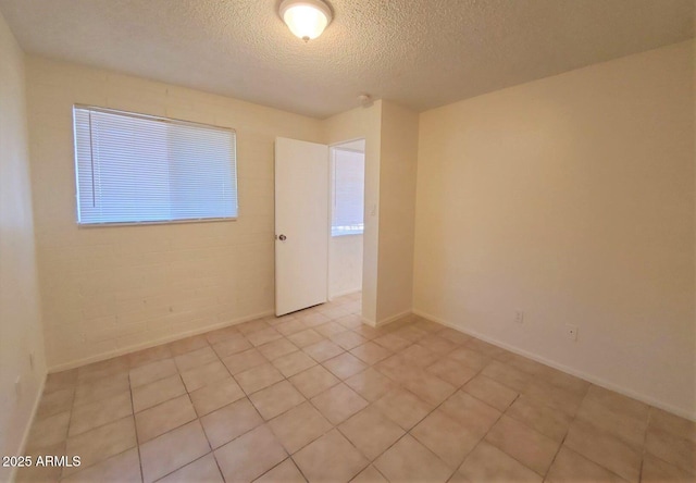 tiled empty room with a textured ceiling