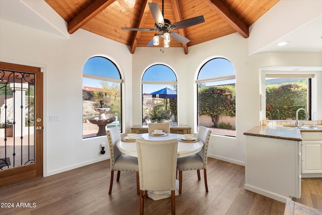 dining space featuring ceiling fan, sink, wooden ceiling, lofted ceiling with beams, and light wood-type flooring