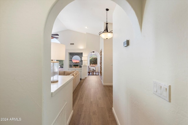 hall with vaulted ceiling and hardwood / wood-style flooring