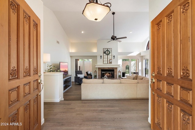 living room featuring ceiling fan, dark hardwood / wood-style flooring, and vaulted ceiling