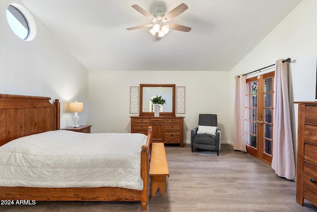 bedroom featuring ceiling fan, french doors, light hardwood / wood-style floors, and vaulted ceiling