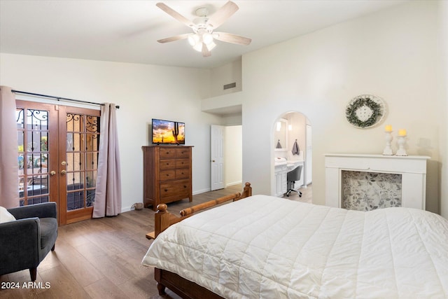 bedroom featuring french doors, ensuite bathroom, ceiling fan, wood-type flooring, and high vaulted ceiling