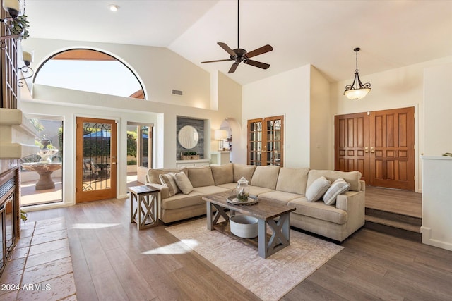 living room with ceiling fan, french doors, high vaulted ceiling, and hardwood / wood-style flooring