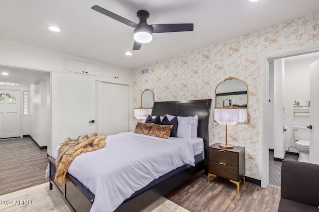 bedroom with ceiling fan, dark hardwood / wood-style floors, a closet, and ensuite bath