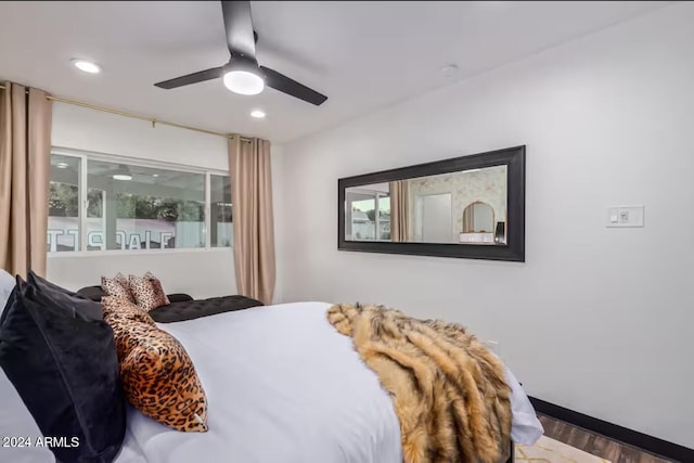 bedroom with hardwood / wood-style floors, multiple windows, and ceiling fan