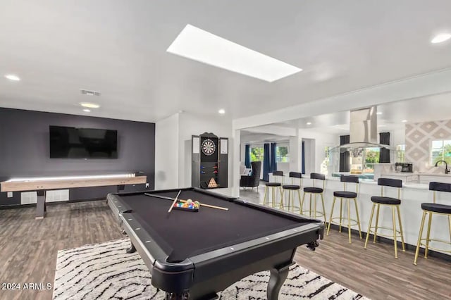 playroom with a skylight, wood-type flooring, billiards, and bar area