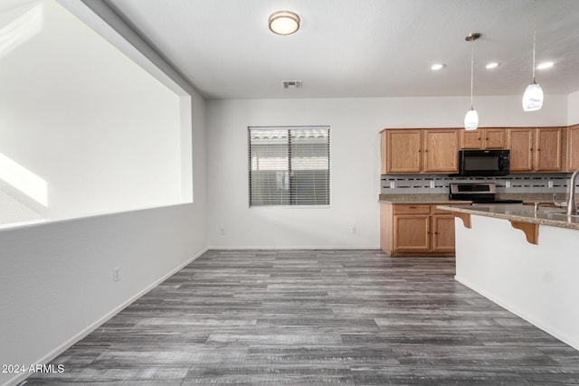 kitchen with dark wood-type flooring, tasteful backsplash, stainless steel range oven, decorative light fixtures, and a breakfast bar