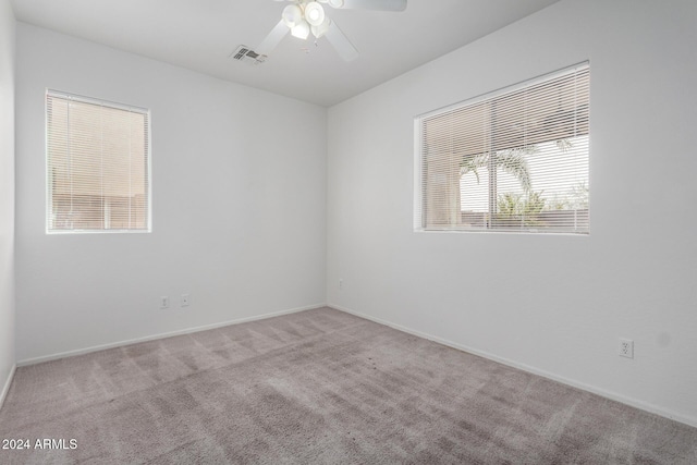 unfurnished room featuring ceiling fan, a healthy amount of sunlight, and light carpet