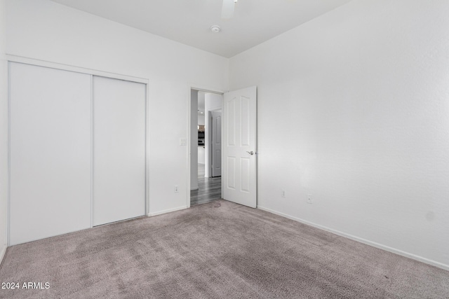 unfurnished bedroom featuring carpet, ceiling fan, and a closet