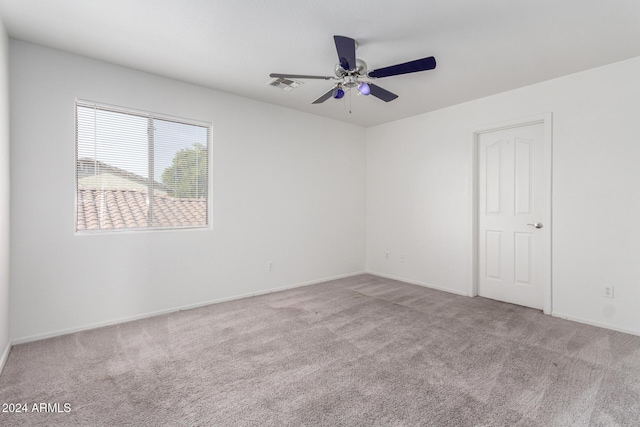 carpeted spare room with ceiling fan