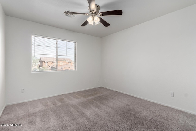 carpeted spare room featuring ceiling fan