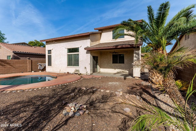 rear view of house featuring a fenced in pool and a patio