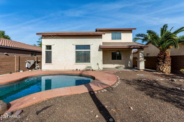 rear view of property with a fenced in pool, ceiling fan, and a patio