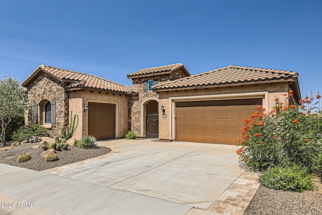 26562 W Vista N Dr, Buckeye, AZ 85396 - mediterranean / spanish-style home featuring stucco siding, a tile roof, stone siding, concrete driveway, and an attached garage