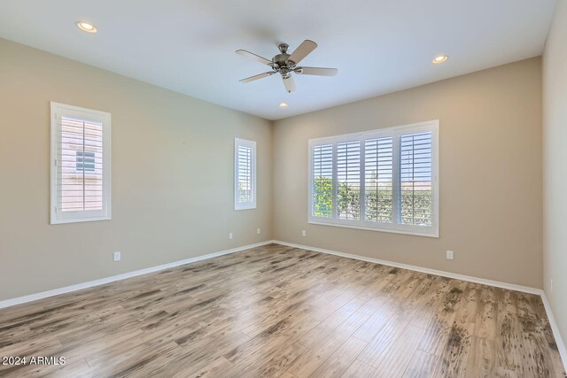 unfurnished room featuring light hardwood / wood-style flooring, a wealth of natural light, and ceiling fan