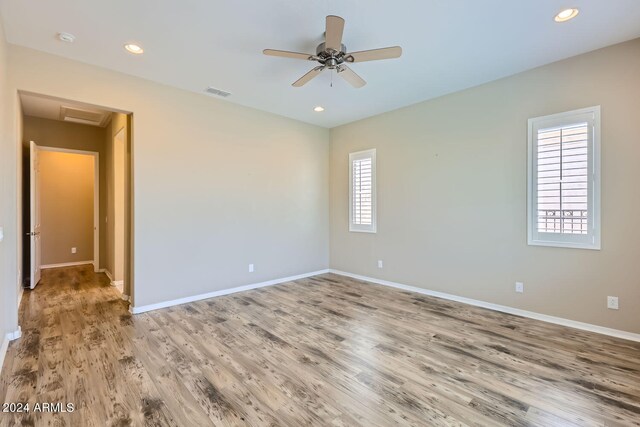 unfurnished room featuring ceiling fan, light hardwood / wood-style floors, and a healthy amount of sunlight