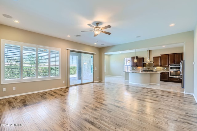 unfurnished living room featuring light hardwood / wood-style floors and ceiling fan