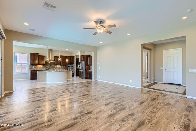 unfurnished living room with ceiling fan and light hardwood / wood-style flooring