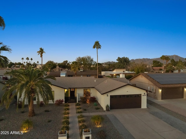 ranch-style house featuring a garage and a mountain view