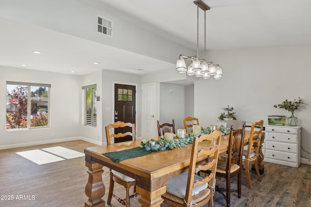 dining room with dark hardwood / wood-style floors and a chandelier