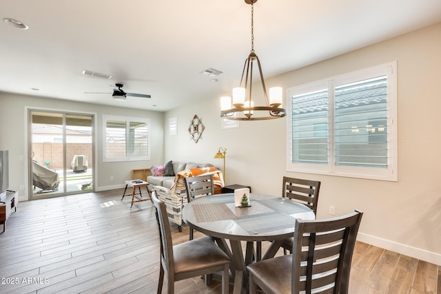 3699 E Sweetclover Ln, San Tan Valley, AZ 85140 - dining space with baseboards, visible vents, ceiling fan with notable chandelier, and light wood-type flooring