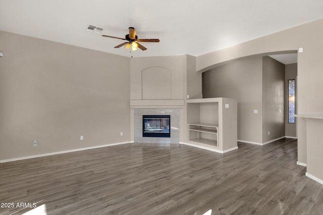 unfurnished living room featuring dark wood-type flooring, a fireplace, and ceiling fan