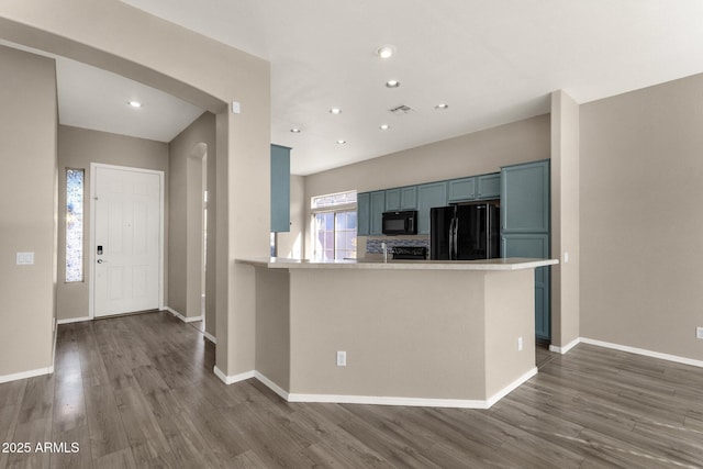 kitchen featuring dark hardwood / wood-style floors, black appliances, kitchen peninsula, and blue cabinets