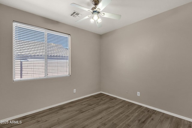 empty room with dark hardwood / wood-style flooring and ceiling fan