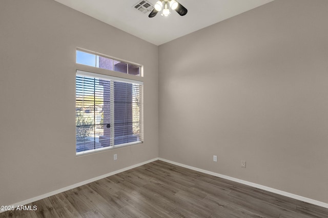 spare room with dark wood-type flooring and ceiling fan