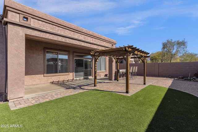 back of property featuring a pergola, a patio area, and a lawn