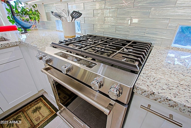32472 N 68th Pl, Scottsdale, AZ 85266 - room details with white cabinets, decorative backsplash, and gas range