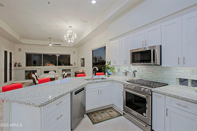 32472 N 68th Pl, Scottsdale, AZ 85266 - kitchen featuring white cabinets, appliances with stainless steel finishes, a sink, a peninsula, and backsplash