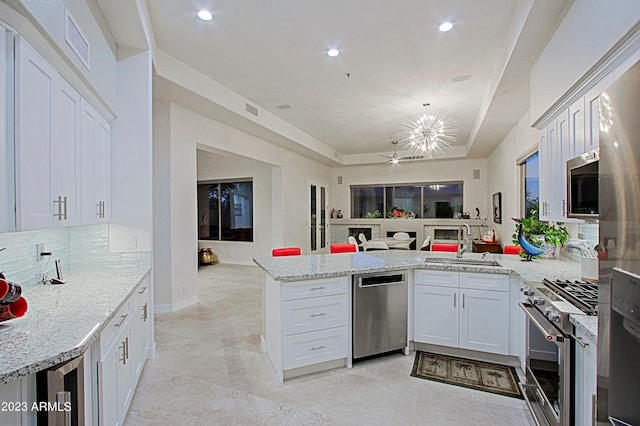 32472 N 68th Pl, Scottsdale, AZ 85266 - kitchen featuring visible vents, a peninsula, open floor plan, a sink, and stainless steel appliances