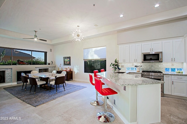 32472 N 68th Pl, Scottsdale, AZ 85266 - kitchen featuring light stone counters, white cabinetry, appliances with stainless steel finishes, and backsplash