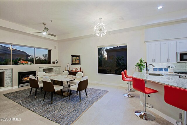 32472 N 68th Pl, Scottsdale, AZ 85266 - dining room featuring baseboards, a chandelier, a glass covered fireplace, a tray ceiling, and recessed lighting