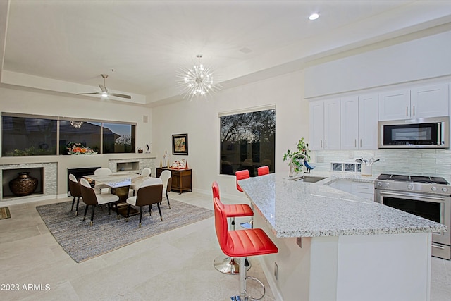32472 N 68th Pl, Scottsdale, AZ 85266 - kitchen with tasteful backsplash, light stone countertops, a sink, white cabinets, and stainless steel appliances