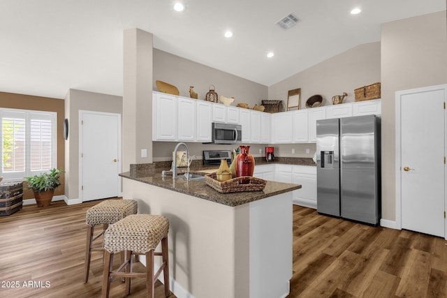 4332 E Cassia Ln, Gilbert, AZ 85298 - kitchen featuring stainless steel appliances, a sink, a peninsula, dark stone countertops, and white cabinetry